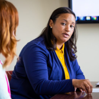 Andrea Gilmore Bykovskyi with members of her research team sit around a table.