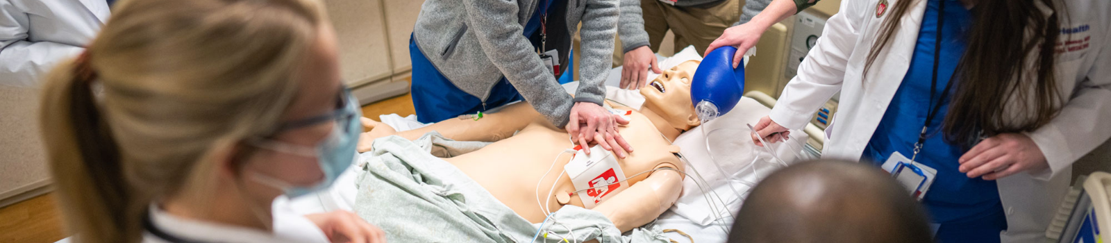 Trainees practice a medical simulation with a manikin