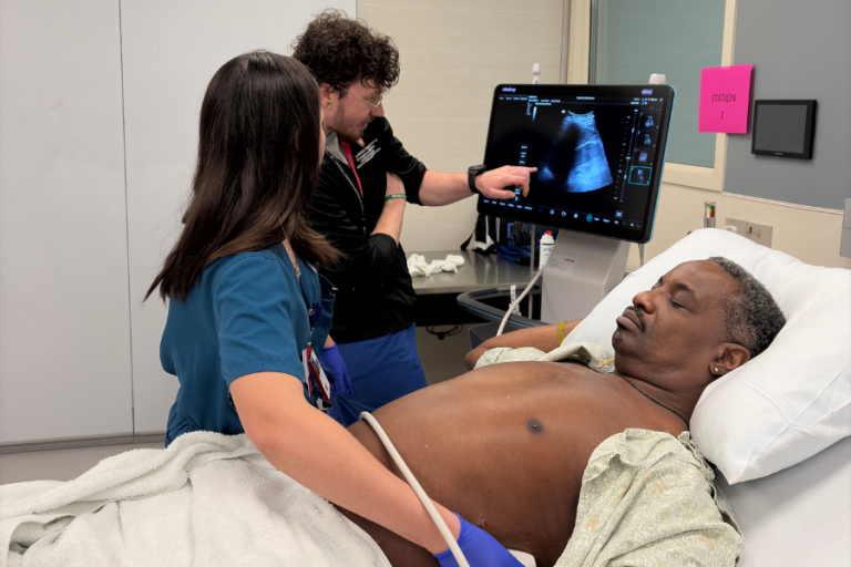 A resident practices ultrasound scanning on a simulated patient.
